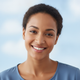 Portrait of a smiling woman, mid-20s to mid-30s, with a happy and trustworthy expression.